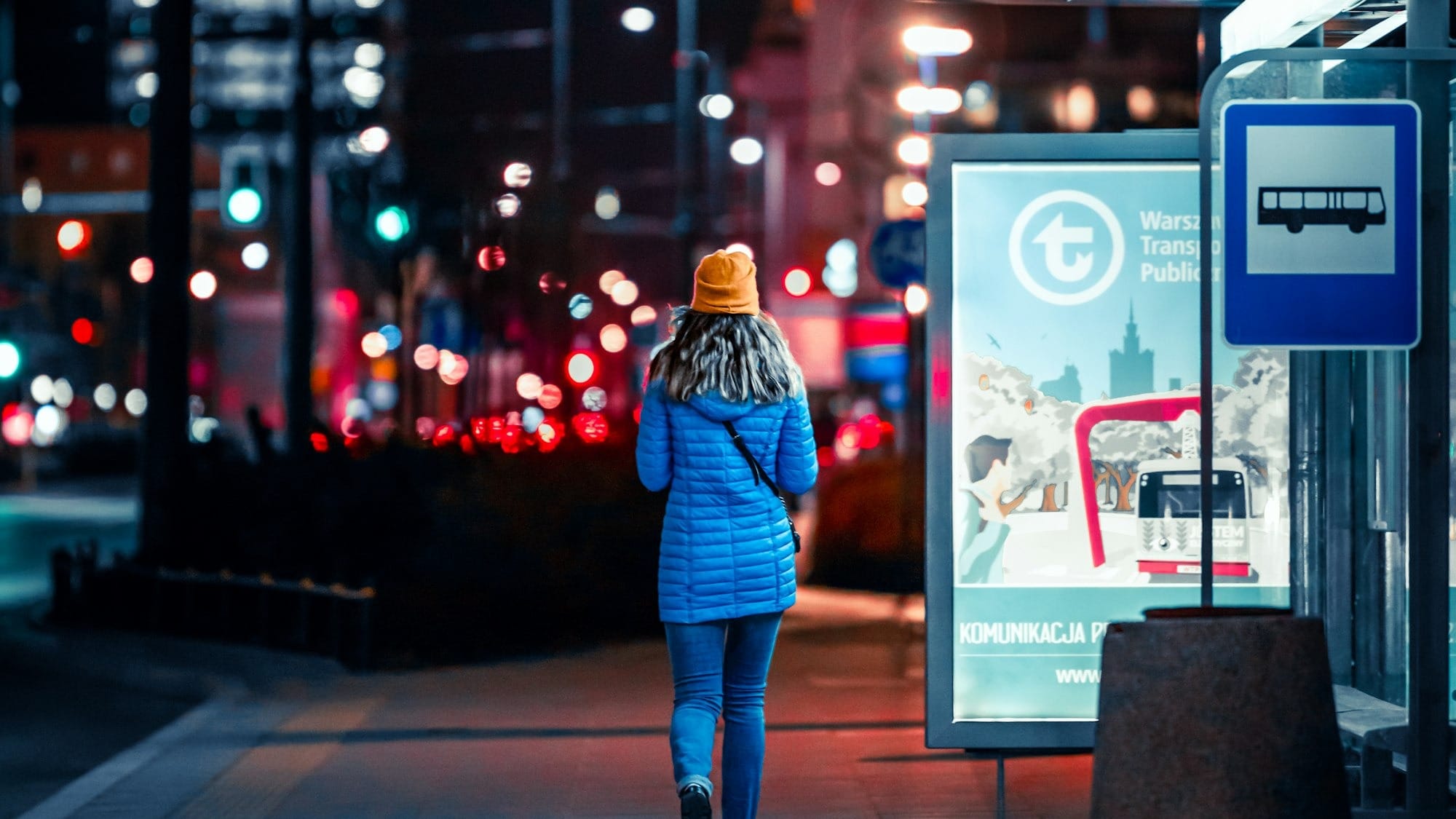 a woman walking down a street at night